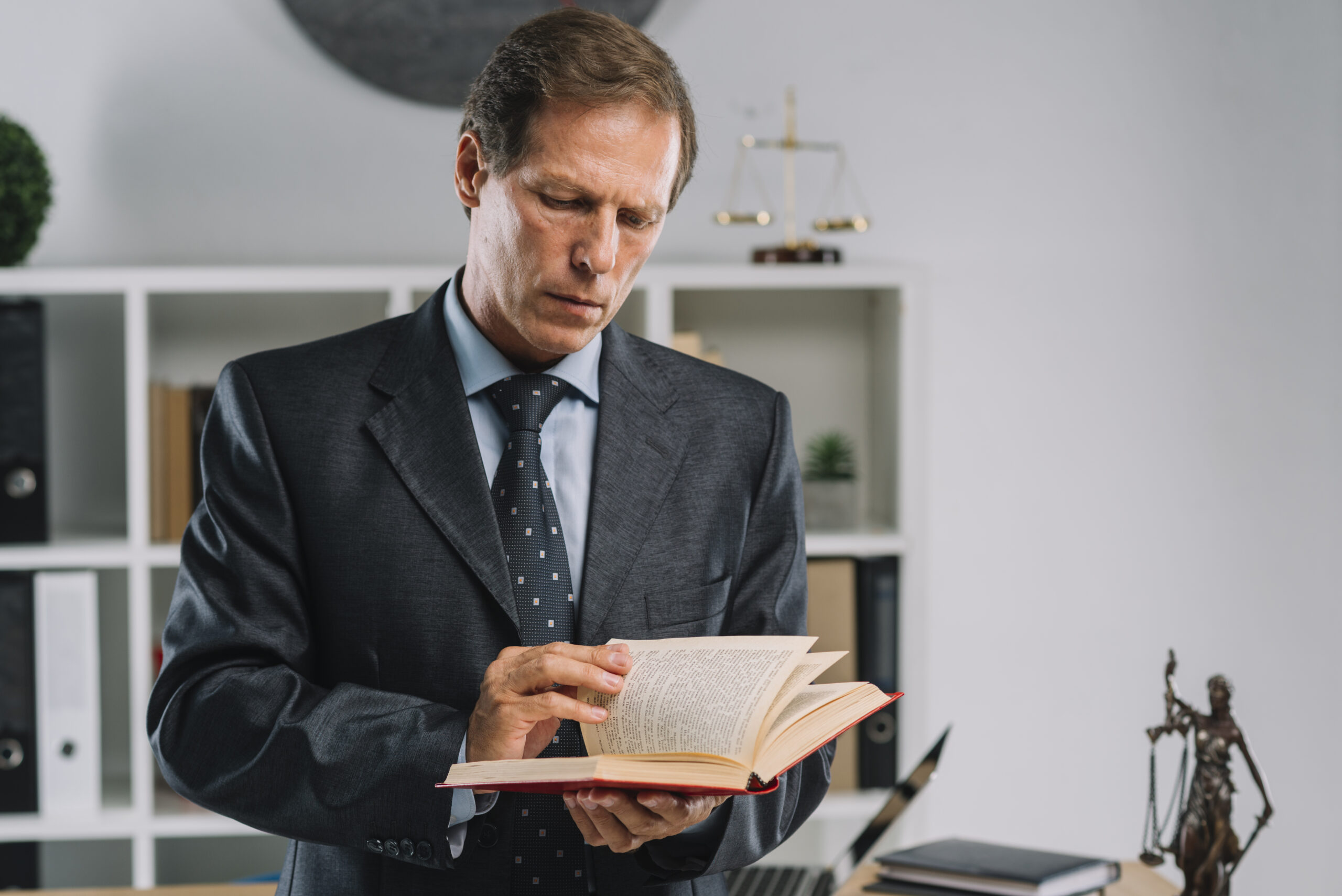 mature-lawyer-turning-pages-law-book-courtroom